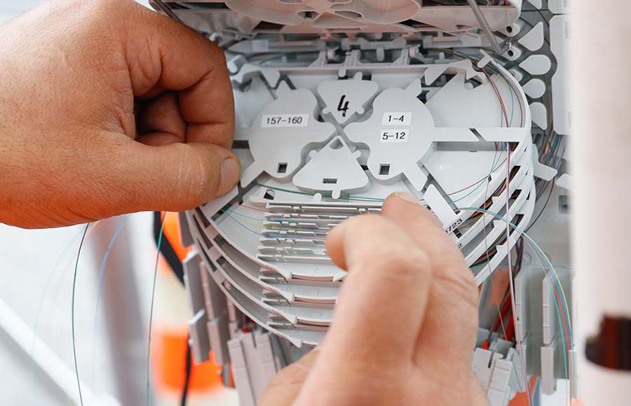 Tecnico che gestisce un modulo fibra – modello a quattro fibre conforme agli standard svizzeri nella rete Massagno4net
