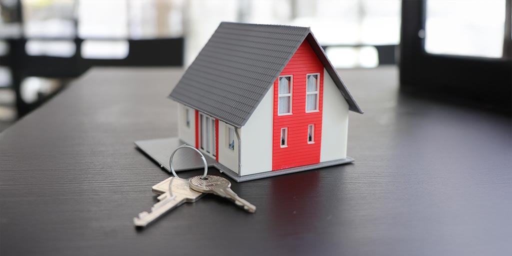 Modellino di casa con chiavi – informazioni per i proprietari di immobili sul collegamento alla rete in fibra ottica FTTH di Massagno4net